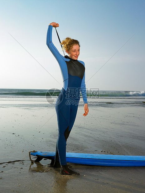女冲浪者站在海滩上图片