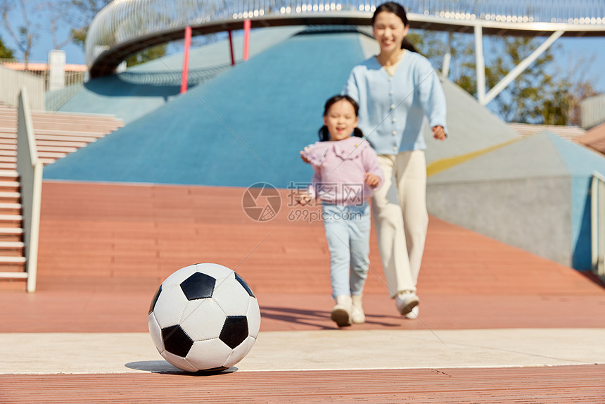 妈妈陪女儿户外玩耍踢足球图片