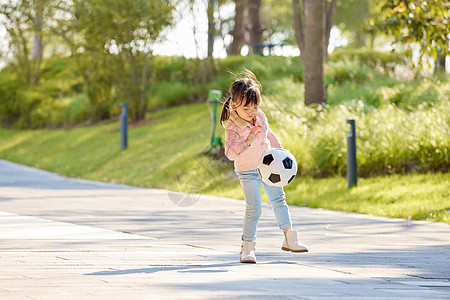 阳光下玩足球的小女孩背景图片