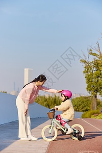 妈妈陪伴女儿骑自行车图片