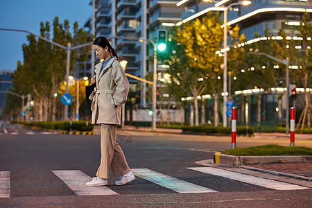 青年女性夜晚下班过马路图片