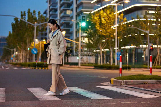 青年女性夜晚下班过马路图片