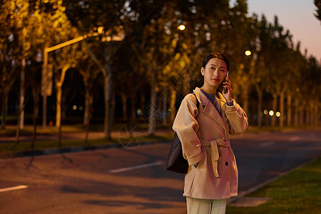 夜间马路年轻女性夜晚路边打电话等待背景