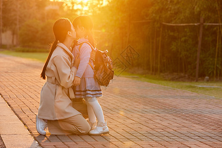 夕阳下妈妈亲吻女儿背景图片