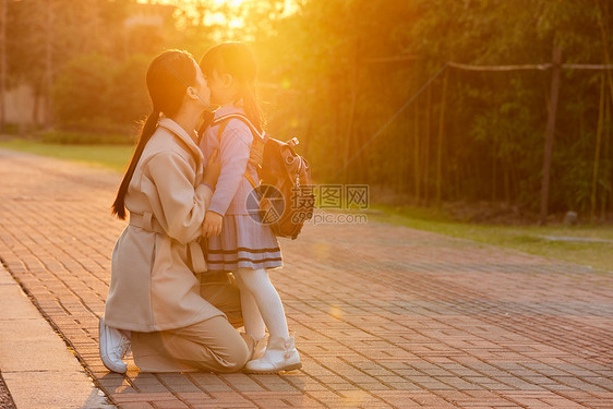 夕阳下妈妈亲吻女儿图片