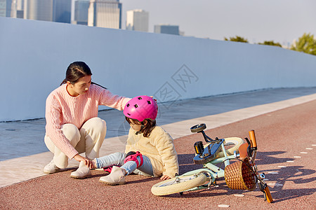 儿童骑车出去玩妈妈检查女儿骑车摔倒的伤势背景