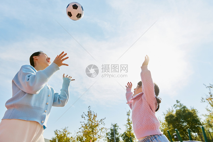 妈妈陪女儿户外玩耍踢足球图片