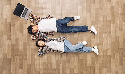 创意俯拍青年情侣躺在地板上放松图片