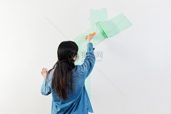 青年女性室内粉刷装修墙面背影图片