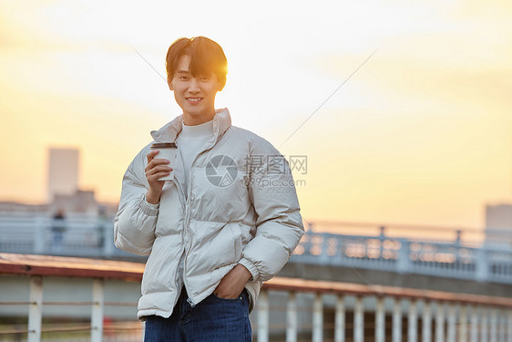 冬季男性夕阳下喝咖啡图片