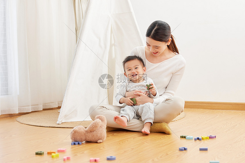 妈妈抱着孩子坐在地上图片