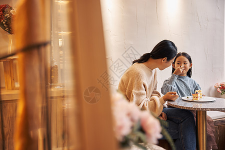 母亲跟女儿在甜品店吃蛋糕图片