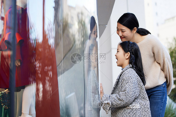 母女看向橱窗里的服装图片