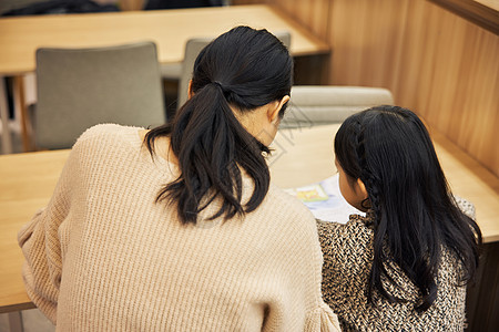 温馨母女坐在书店阅读背影图片