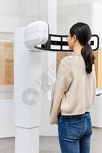 验光机器前检查视力的年轻女性背影图片