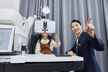 验光师正在给小女孩验光检查视力图片