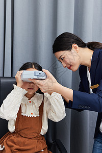 验光师在指导小女孩用专业验光仪器检查视力图片