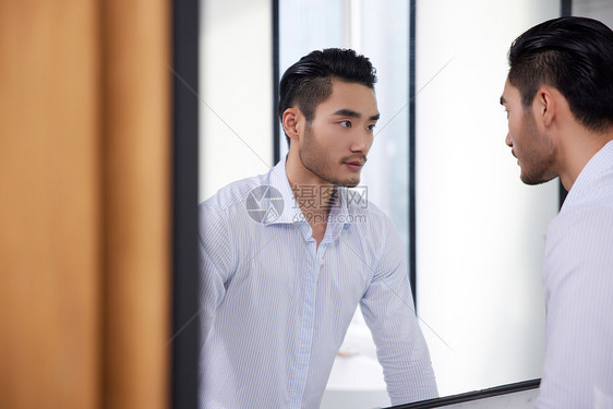 成熟男性对着镜子整理仪表图片