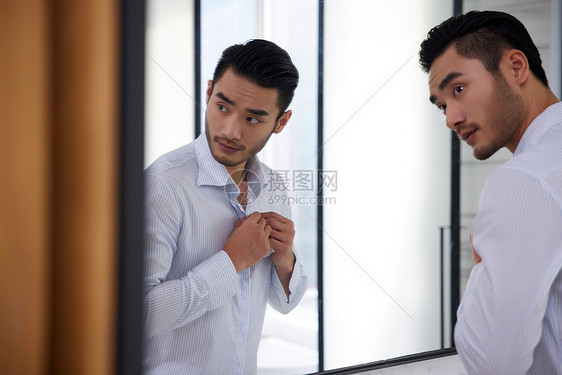 对着镜子整理仪表的成熟男性图片