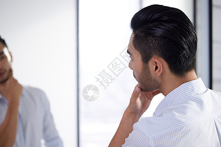 成熟男性对着镜子整理仪表图片