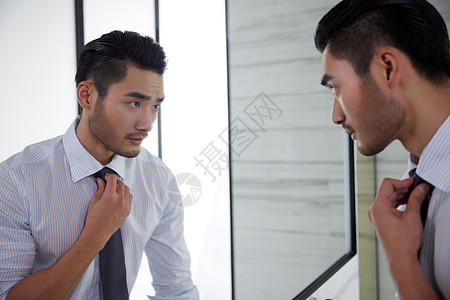 对着镜子整理领带的成熟男人图片