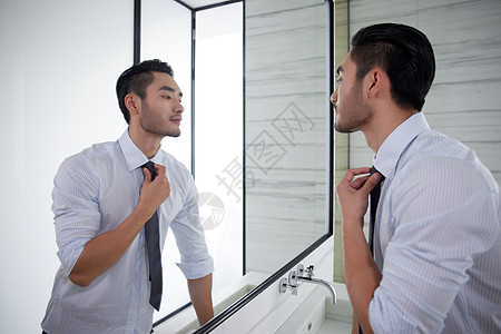 男人在对着镜子整理领带图片