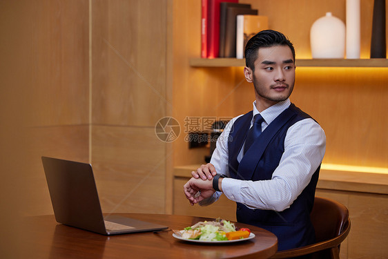 在餐桌上吃色拉的职场男士图片