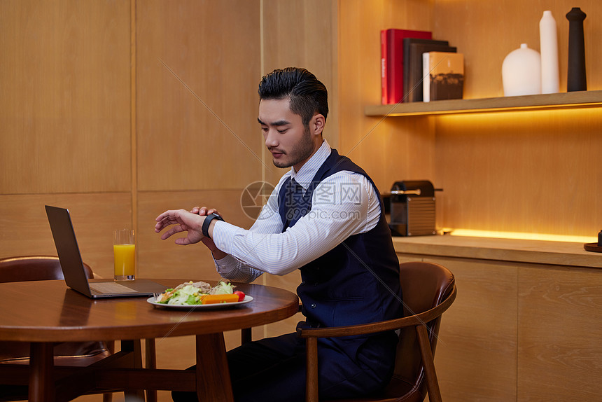 坐在圆形餐桌上吃早餐的商务男性图片