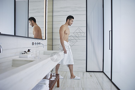 成熟男士裹着浴巾进入洗手间图片