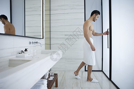 男性裹着浴巾准备洗漱图片