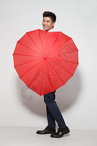 青年男人拿着心形红雨伞高清图片