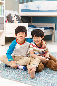 两个男孩坐在卧室的地毯上高清图片