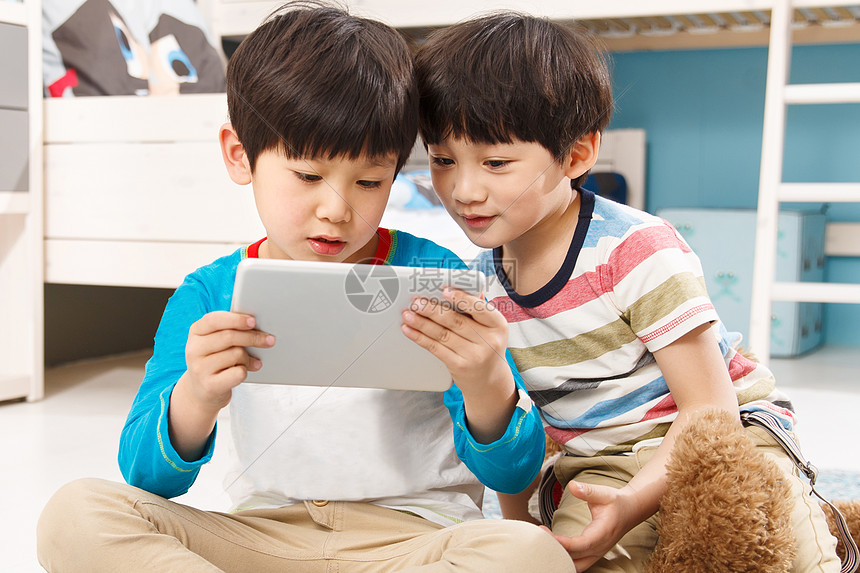 两个男孩在使用平板电脑图片