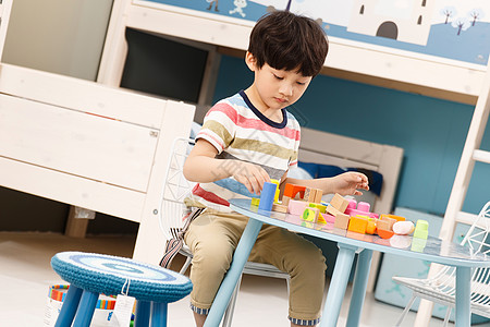 家庭娱乐室可爱的小男孩玩积木背景
