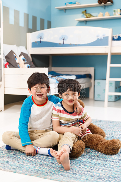 两个男孩坐在卧室的地毯上图片