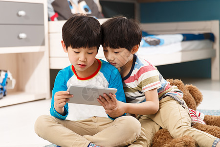 家庭娱乐室两个男孩在使用平板电脑背景