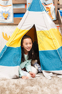兴奋可爱的小女孩在帐篷里玩耍图片