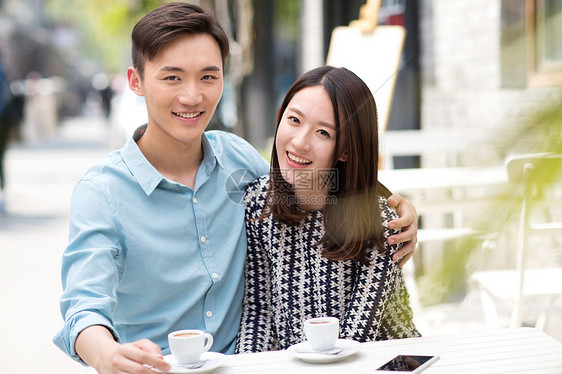 东方人市区异恋青年情侣坐在咖啡馆里图片