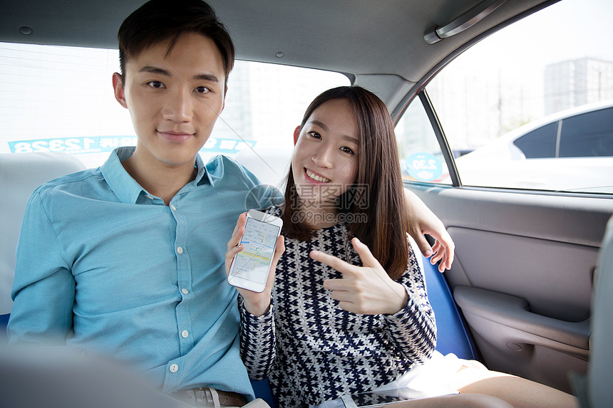 青年情侣在车内拿着手机导航图片