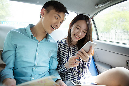 微笑美女青年情侣在车内看手机背景