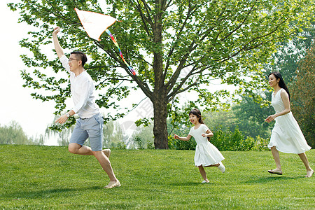 孩子跑步一家三口在草地上放风筝背景
