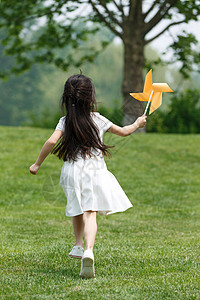 风车玩具庭院小女孩在草地上玩耍背景