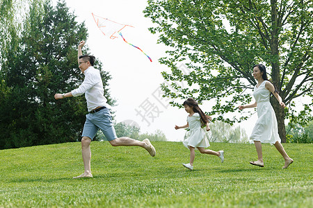 一家旅游安全环境青年女人一家三口在草地上玩耍背景