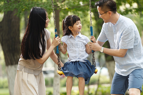 青年人独生子家庭休闲快乐的一家三口荡秋千图片