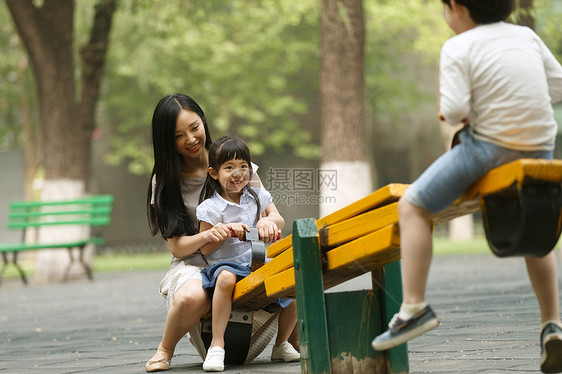 休闲活动无忧无虑不看镜头快乐母女玩跷跷板图片