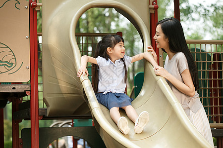 家庭保护绿色母亲独生子家庭小女孩滑滑梯背景