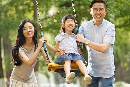 母亲白昼休闲快乐的一家三口荡秋千图片素材