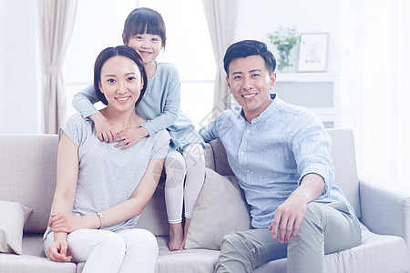 亲子双亲家庭东亚幸福的一家三口在客厅看电视图片