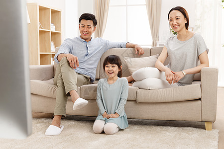 住宅内部核心家庭妻子幸福的一家三口在客厅看电视图片
