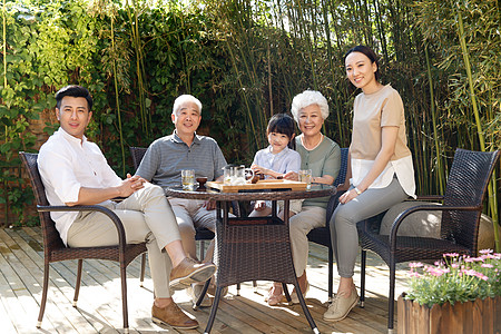 快乐幸福家庭在院子里喝茶图片